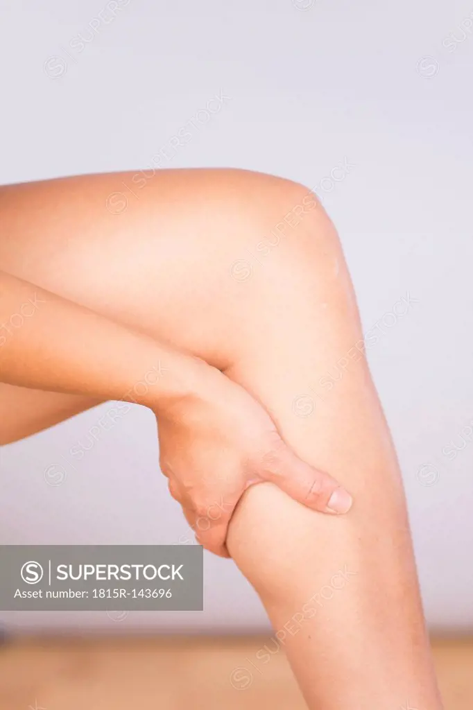 Germany, Freiburg, Mid adult woman massaging her knee, close up