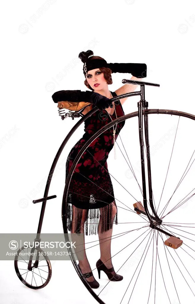 Portrait of young woman holding cycle on white background