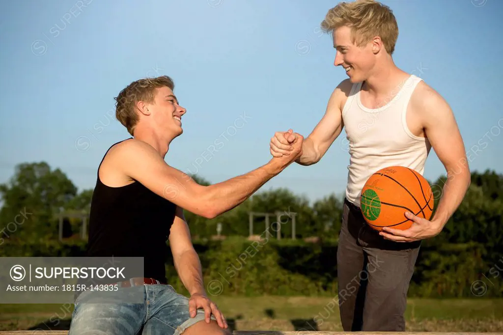 Germany, Two young men meeting up to play basketball