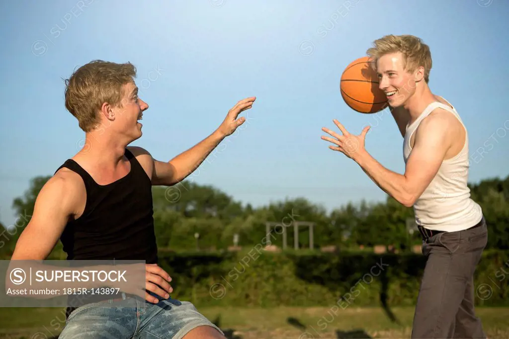 Germany, Two young man meeting up to play basketball