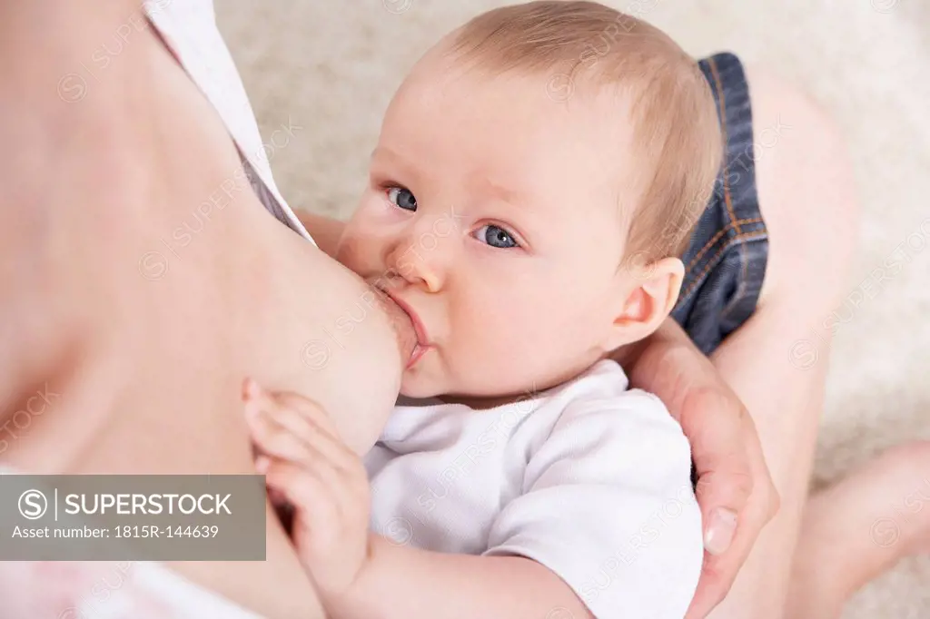 Germany, North Rhine Westphalia, Cologne,Mother breastfeeding her daughter, close up