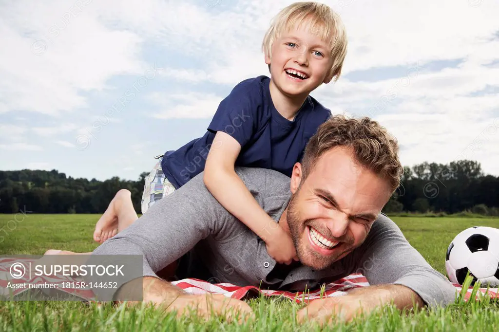 Germany, Cologne, Father and son playing around on picnic blanket