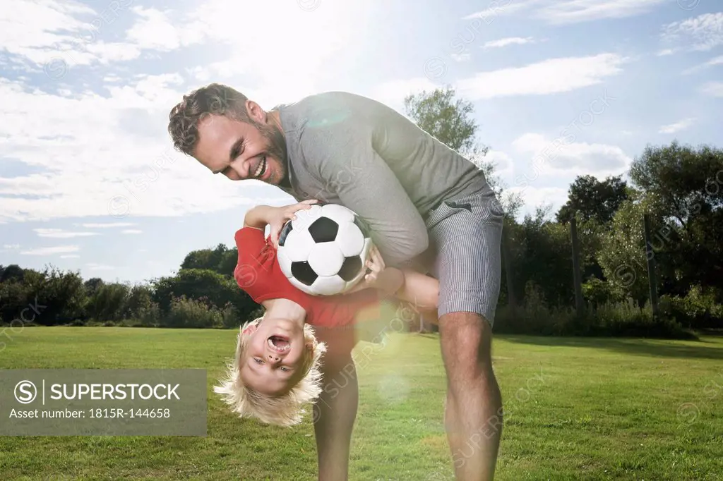Germany, Cologne, Father and son playing soccer