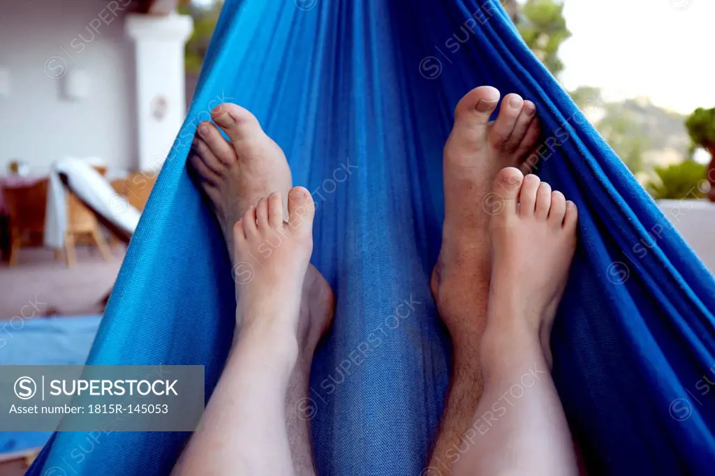 Spain, Mid adult man and boy legs relaxing on hammock