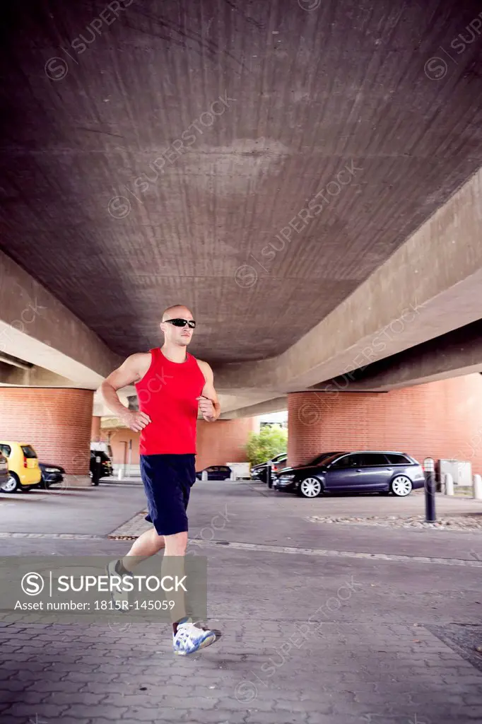 Man jogging under a bridge