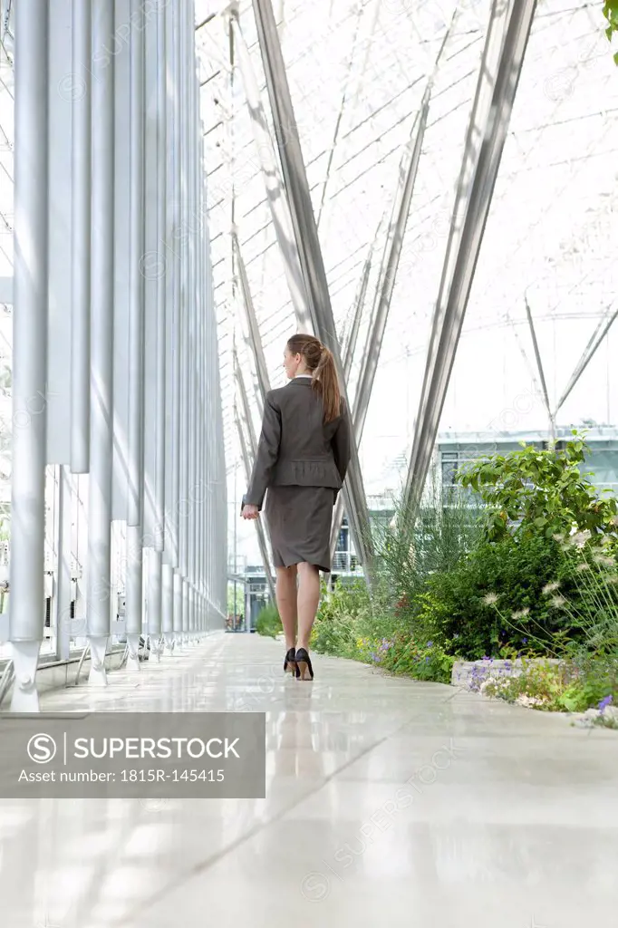 Businesswoman walking in modern courtyard