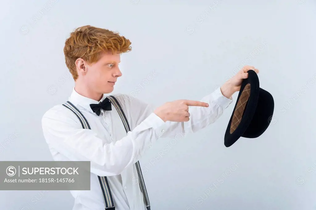 Young man showing magic with hat