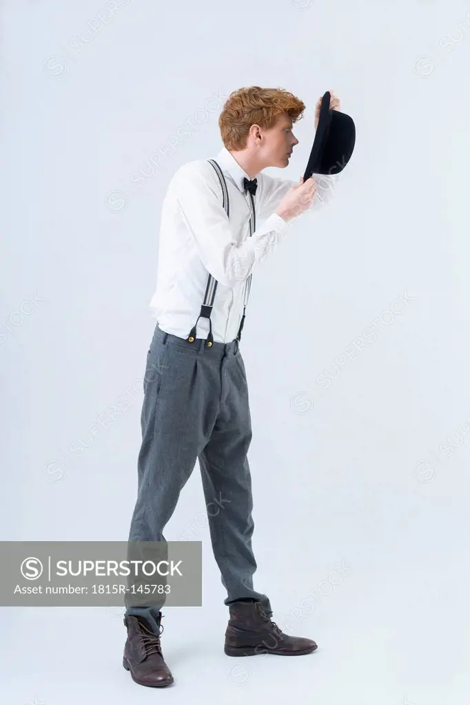 Young man showing magic with hat