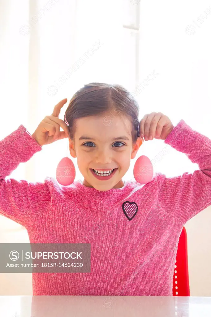 Portrait of laughing girl with pink Easter eggs