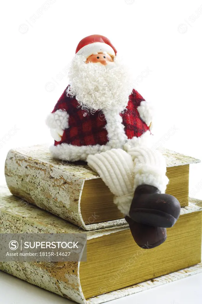 Santa Claus figurine sitting on books