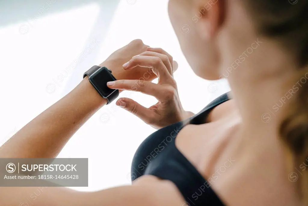 Close-up of woman in sportswear adjusting her smartwatch