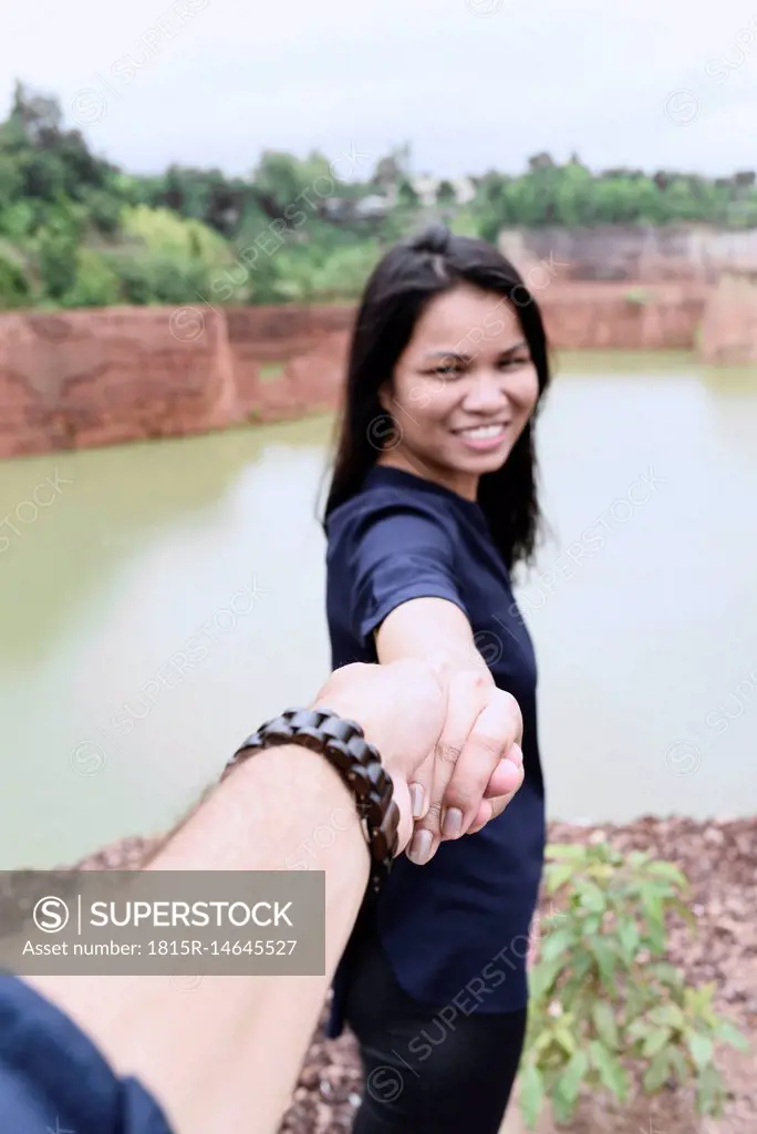 Thailand, Chiang Mai, happy young woman holding hand of her partner at grand canyon