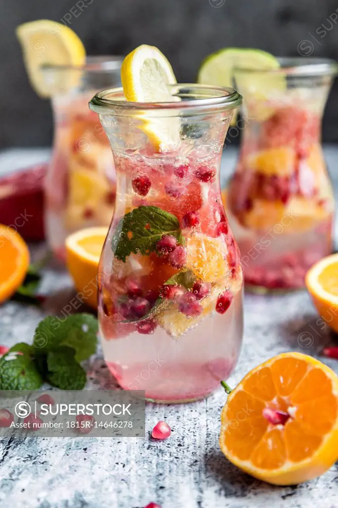 Detox water, glass of infused water with citrus fruits, pomegranate seed and mint