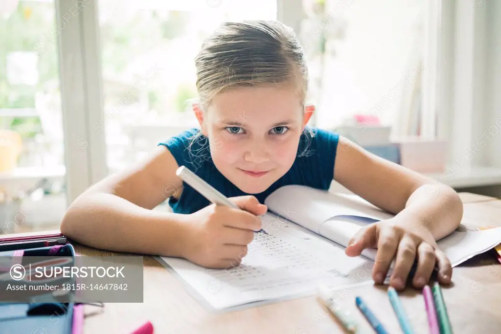 Portrait of girl doing homework at table