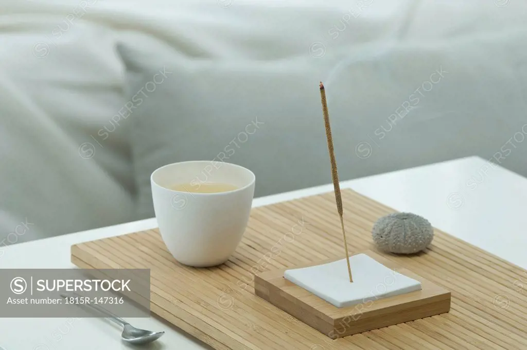 Aromatheraphy, tea, scent, aroma sticks, sea urchin shell, wellness, with a bed visible in the backgroud, studio