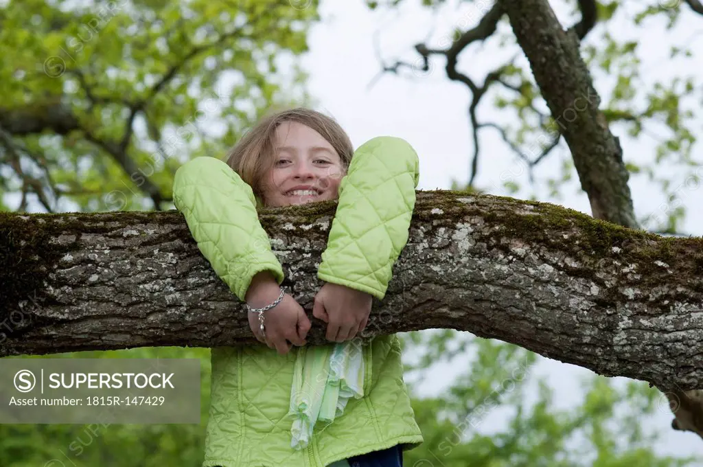 Germany, Bavaria, girl climbing on a tree