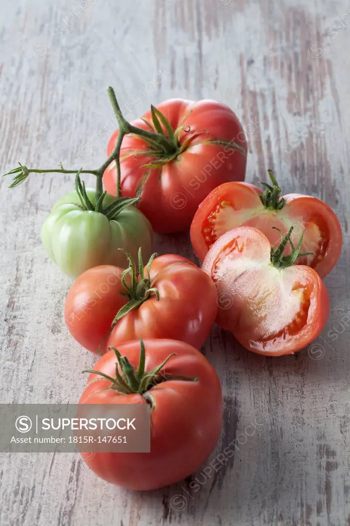 Whole and sliced Silesian raspberry tomatoes (Solanum lycopersicum), studio shot