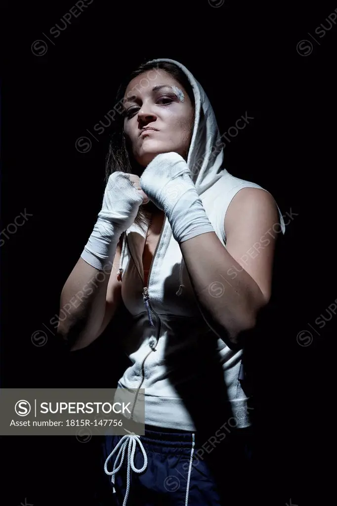 Portrait of a young female boxer holding fists up