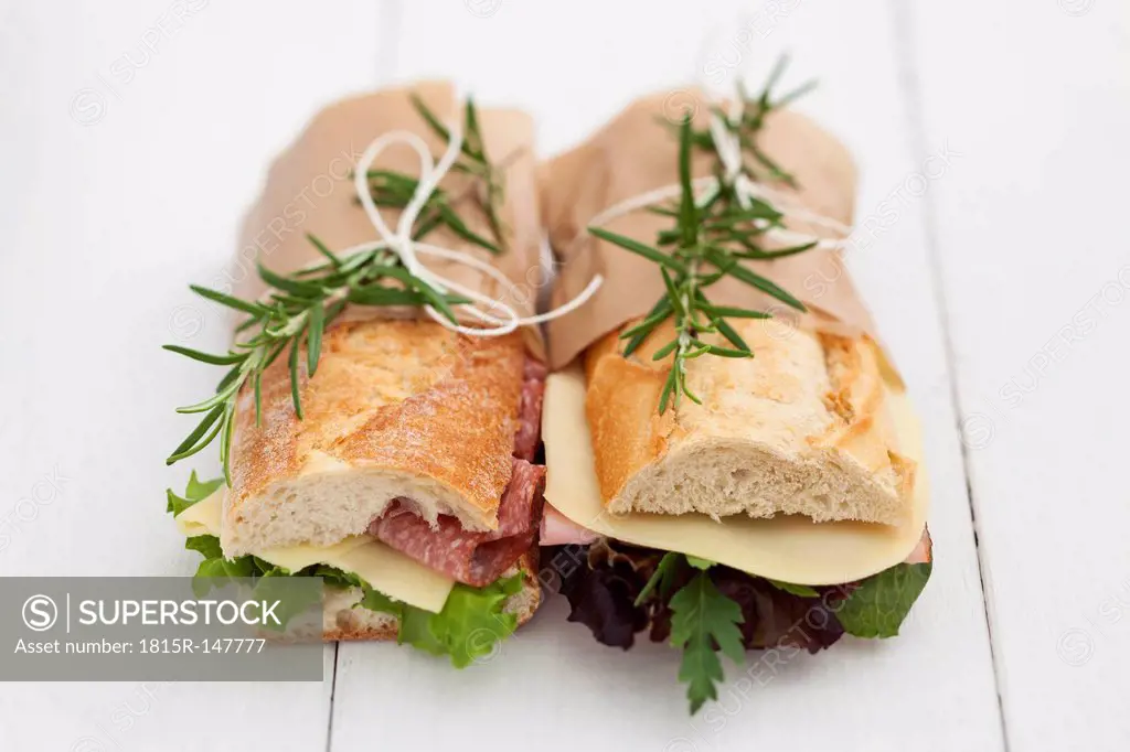 Baguette sandwiches with rosmary on white wood boards