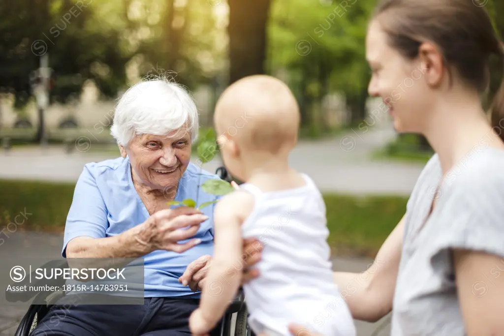Portrait of happy senior woman with daughter and granddaughter in a park