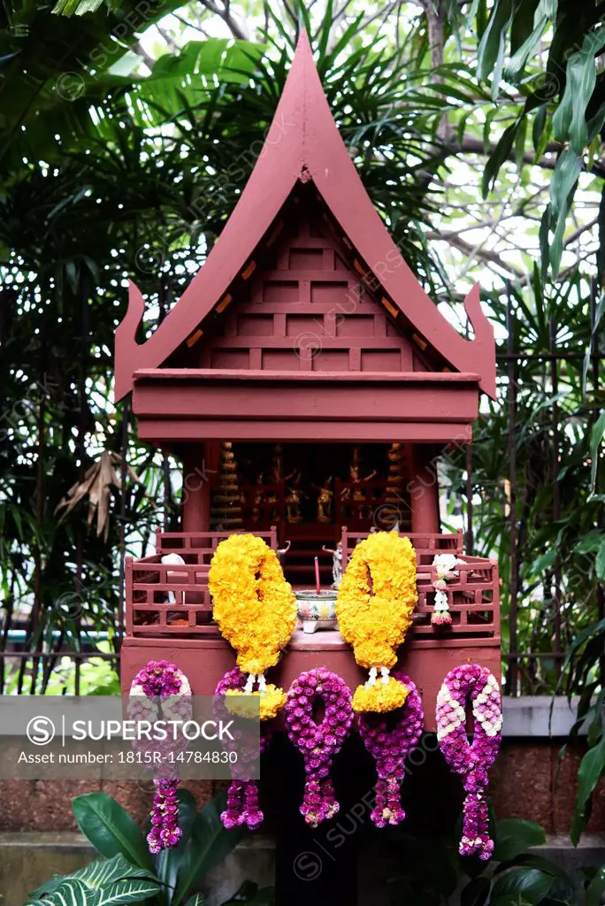 Thailand, Bangkok, Thai-style house replica as small buddhist chapel decorated with flowers