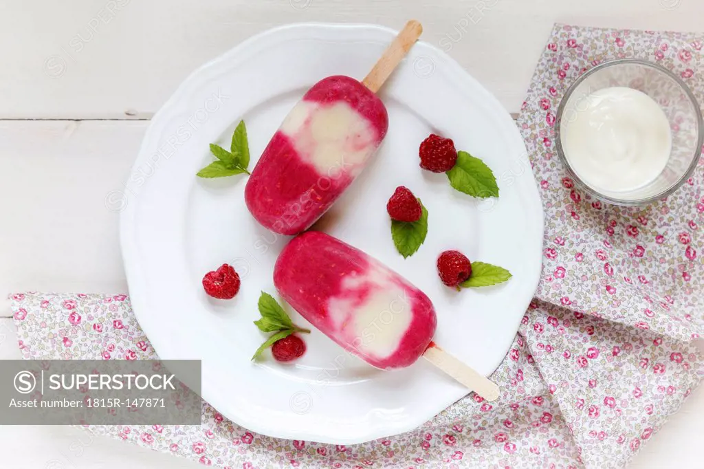 Rasperry-Yoghurt popsicles on plate, studio shot