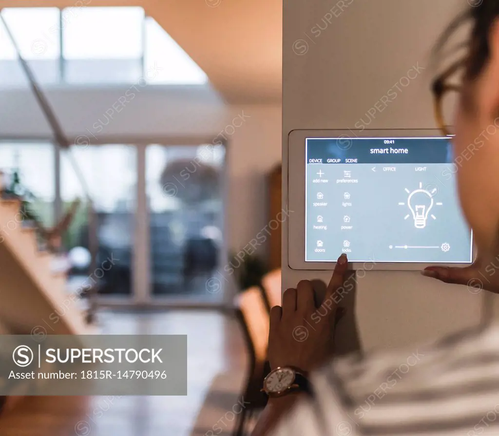 Woman using screen with smart home control functions at home