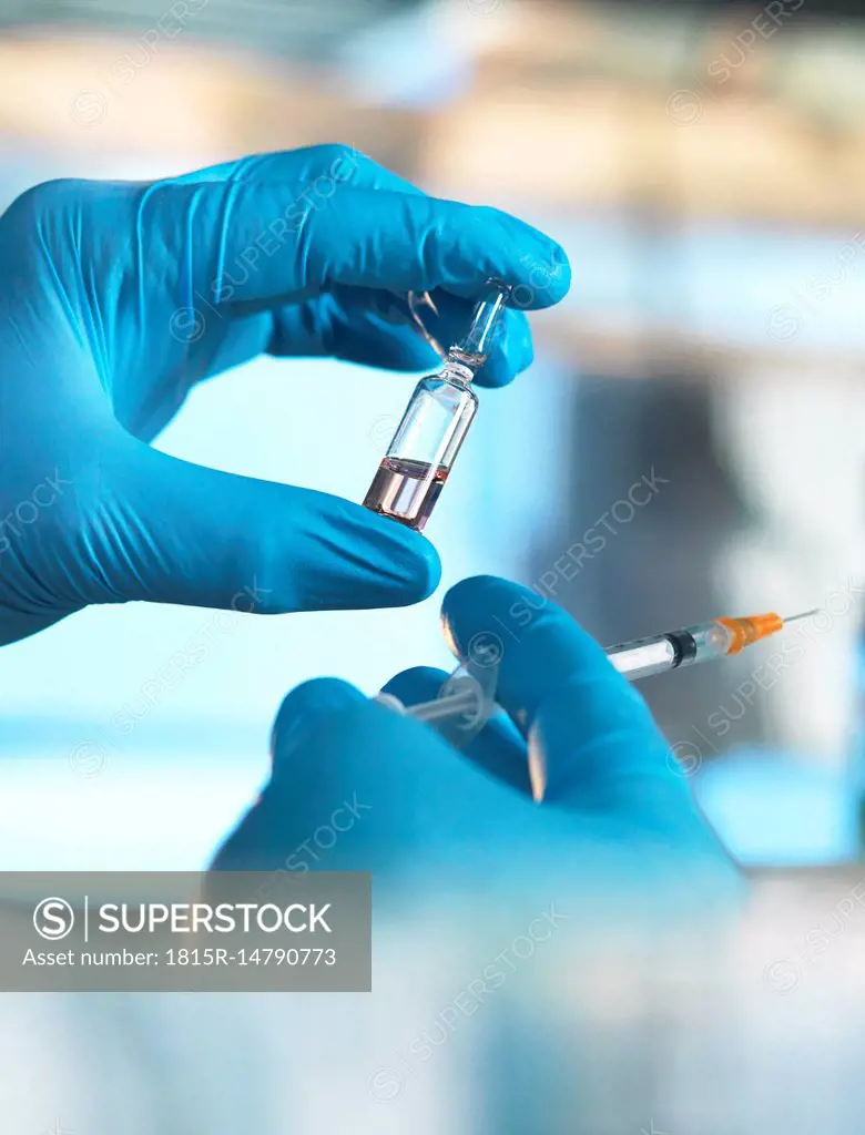 Scientist holding a vial containing a liquid in the laboratory