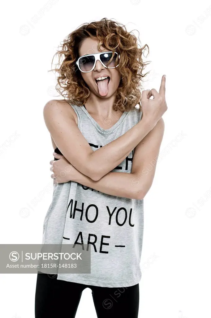 Young woman with sunglasses outstretching her tongue, studio shot