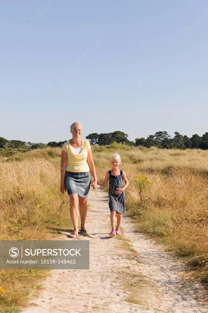 France, Bretagne, Landeda, Mother and daughter walking on dune path