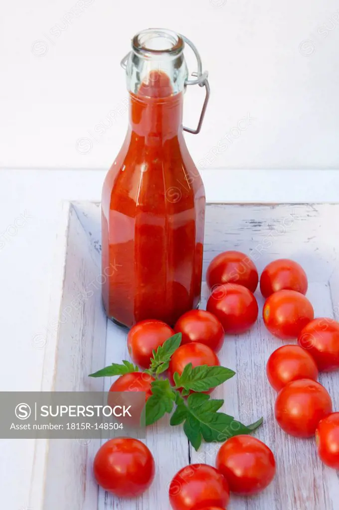 Homemade tomato sauce in wooden tray with tomatoes, close up