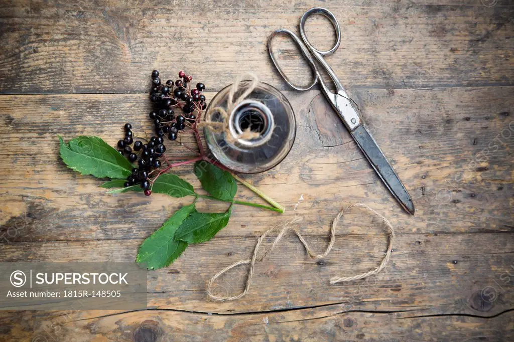 Elderberry juice, elderberries and scissors on a wooden table