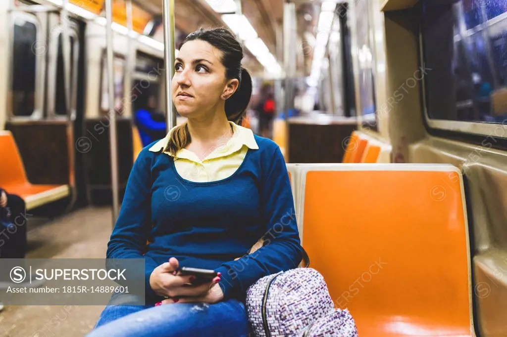 USA, New York, woman with cell phone in subway