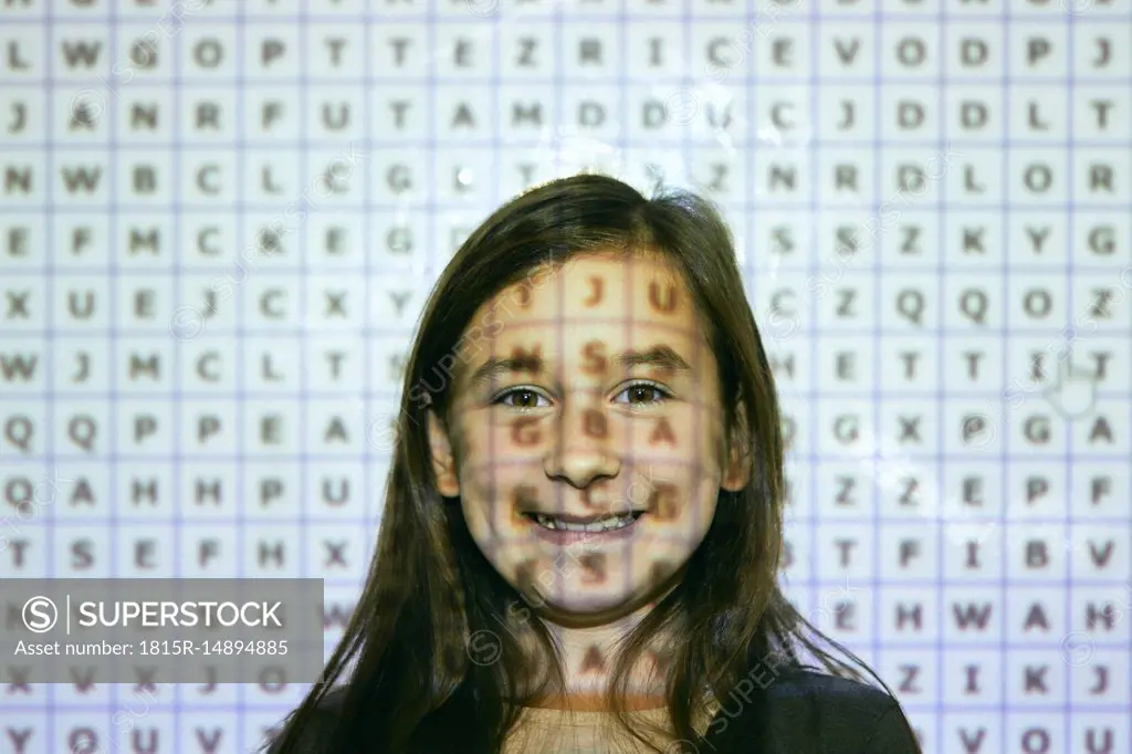 Portrait of smiling schoolgirl in front of interactive whiteboard