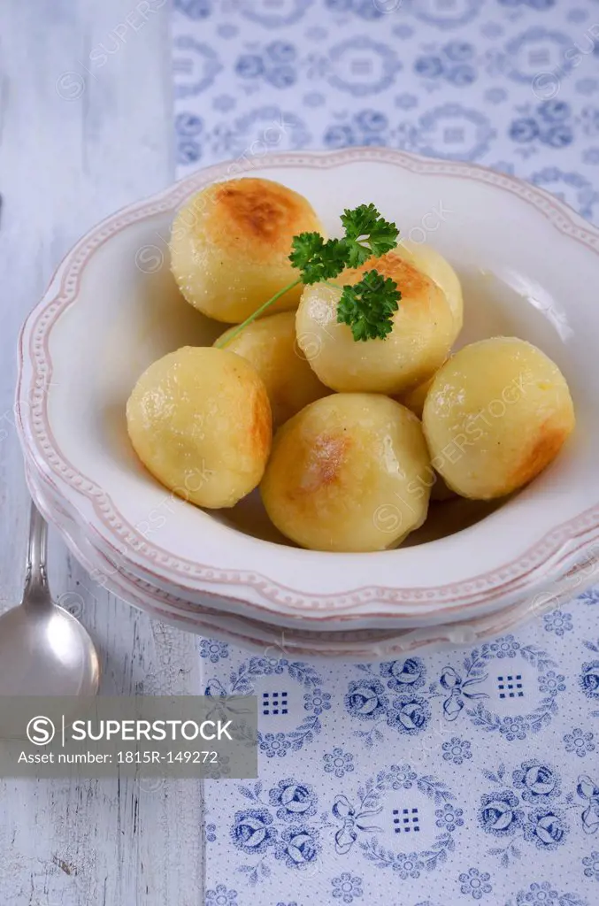 Fried potato dumplings in a bowl, studio shot