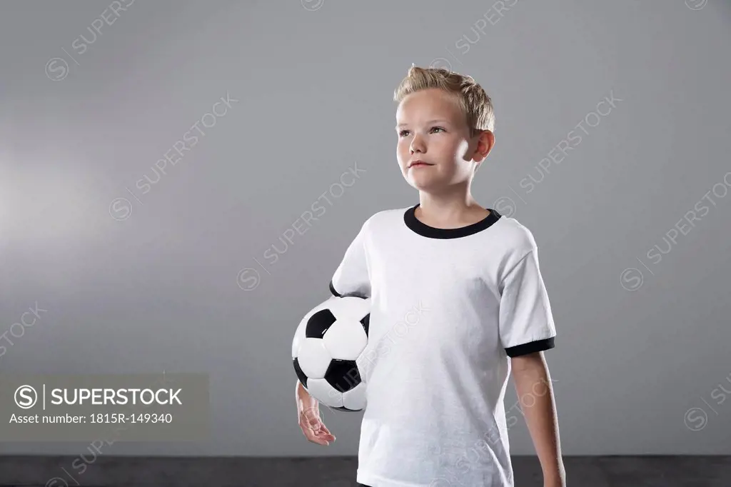 Boy in soccer jersey holding ball