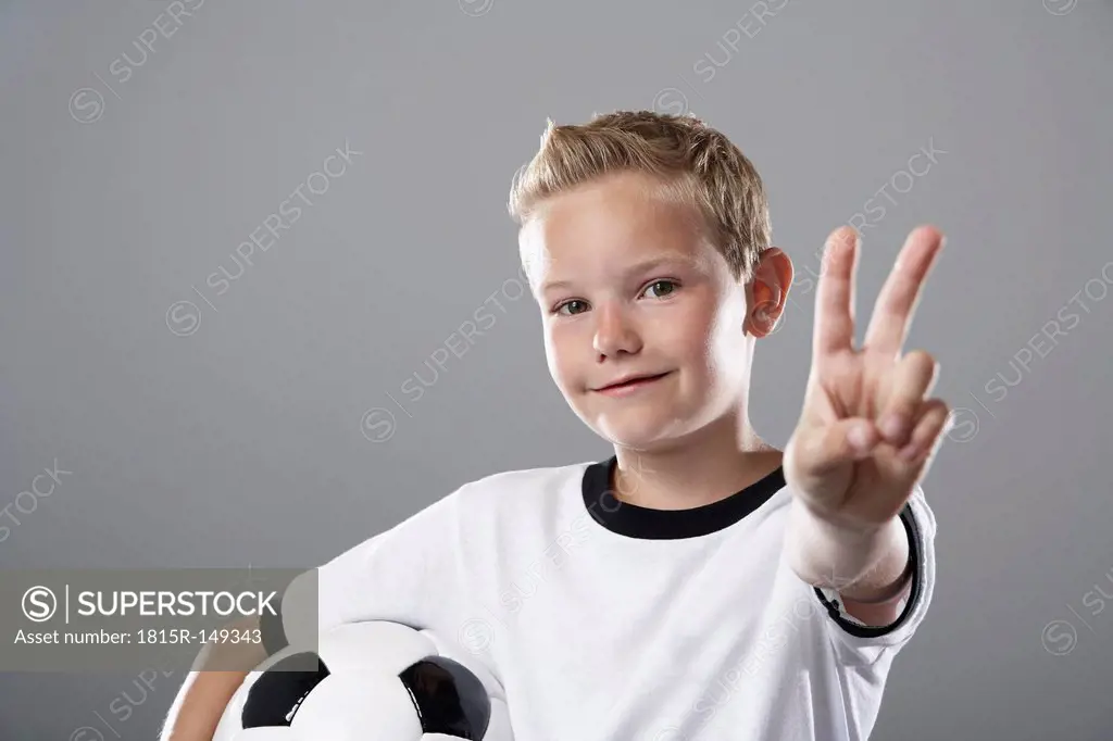 Boy in soccer jersey doing victory sign