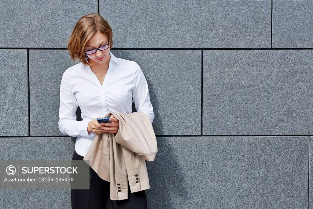 Germany, Businesswoman holding smart phone