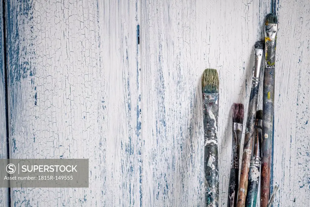 Old brushes leaning on wooden boards
