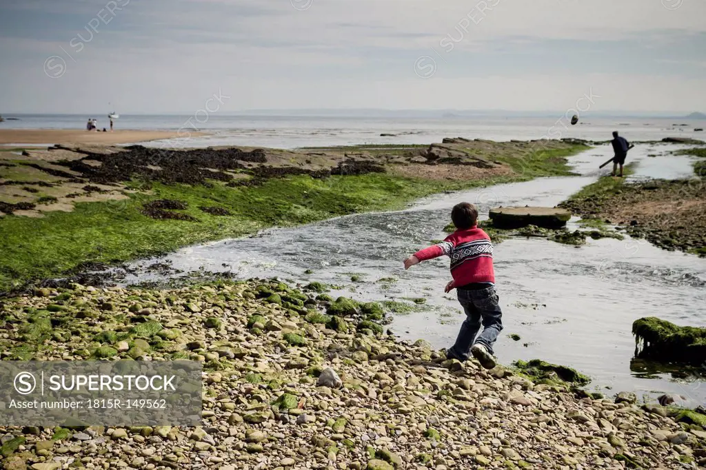 Great Britain, Scotland, Fife, Anstuther, boy throwing stones into water