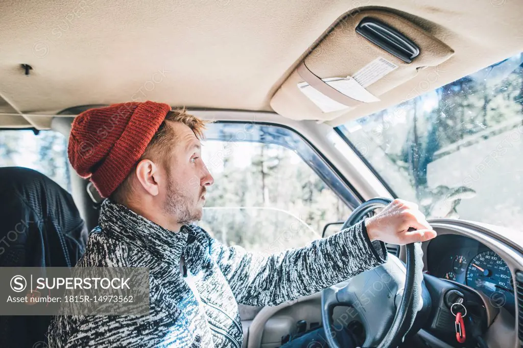 Young man with woolly hat and beard on a road trip