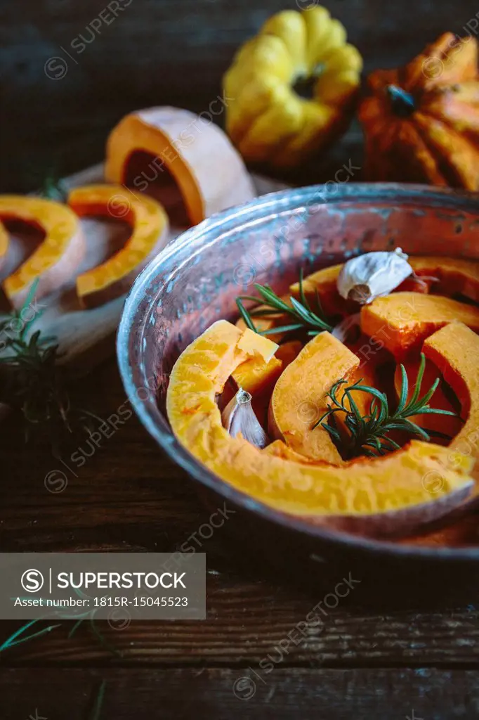 Pumpkin slices, garlic and rosemary in casserolle