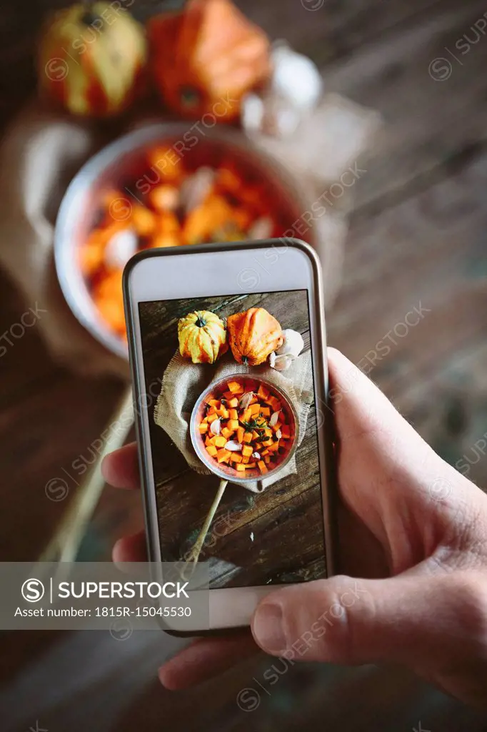 Taking photo of casserolle of pumpkin dish with smartphone