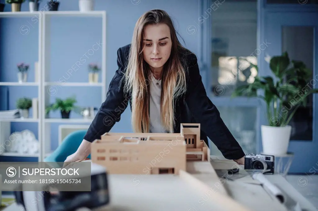 Architect looking at architectural model in office