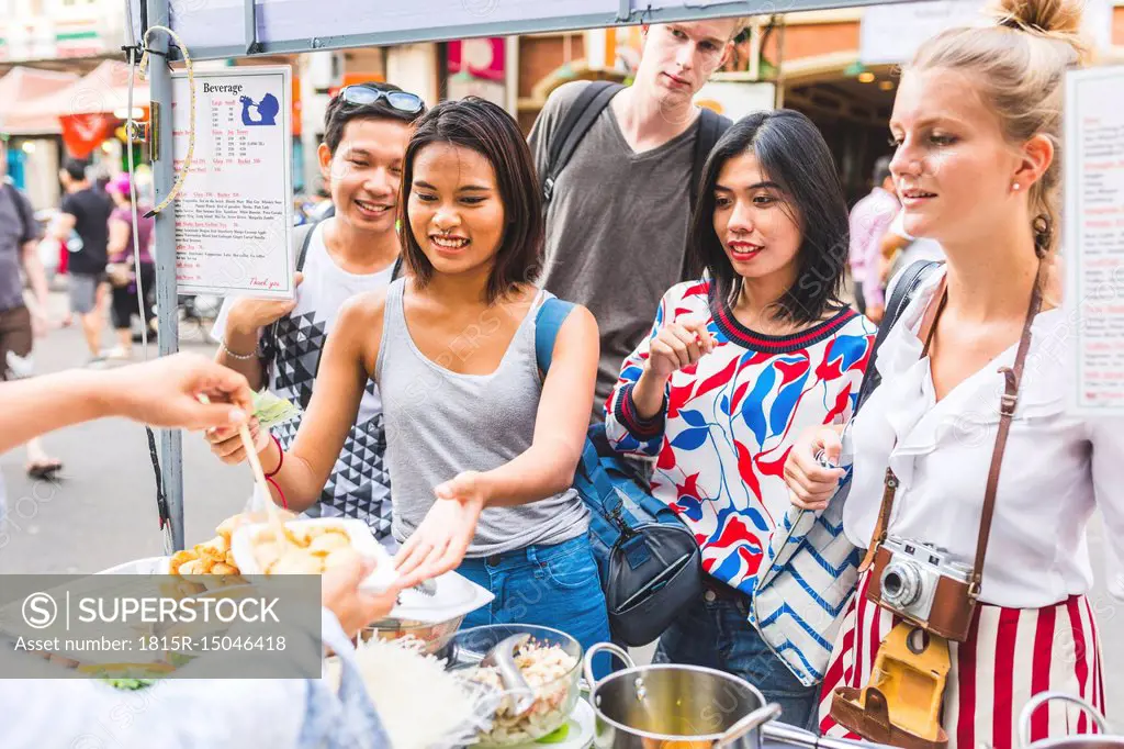 Thailand, Bangkok, Khao San Road, group of friends testing local food on street market