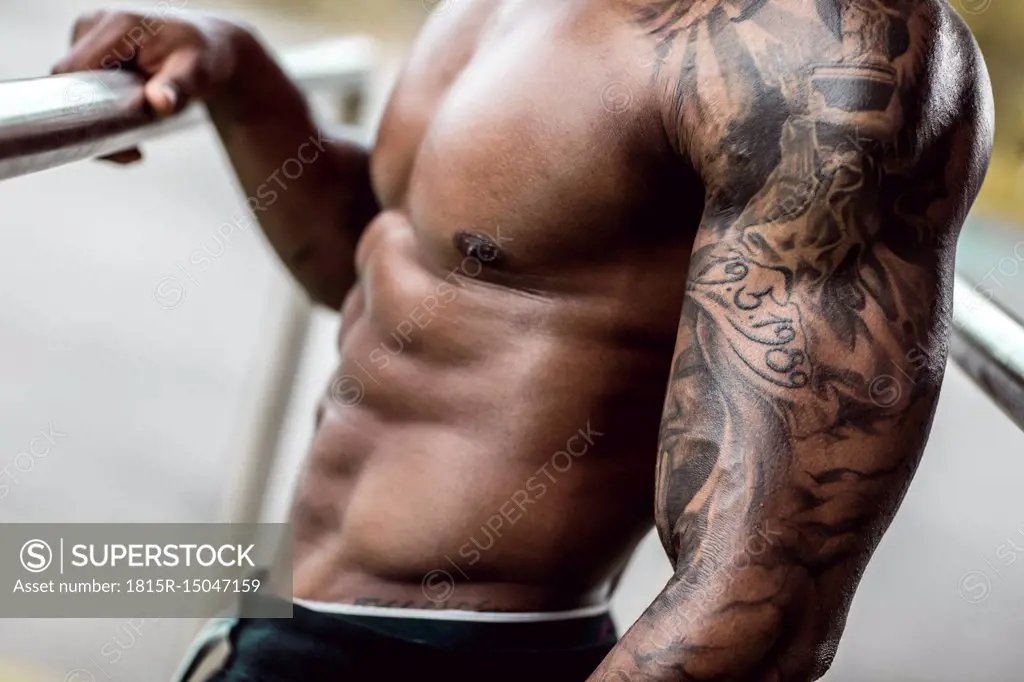 Tattooed biceps of physical athlete, close-up