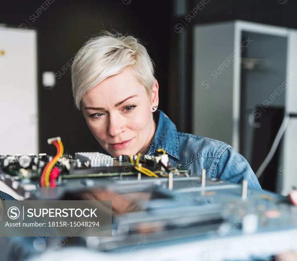 Woman examining computer equipment