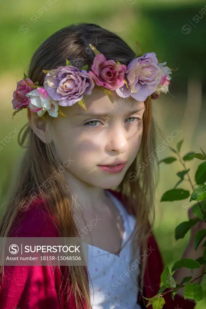Portrait of daydreaming little girl wearing flowers