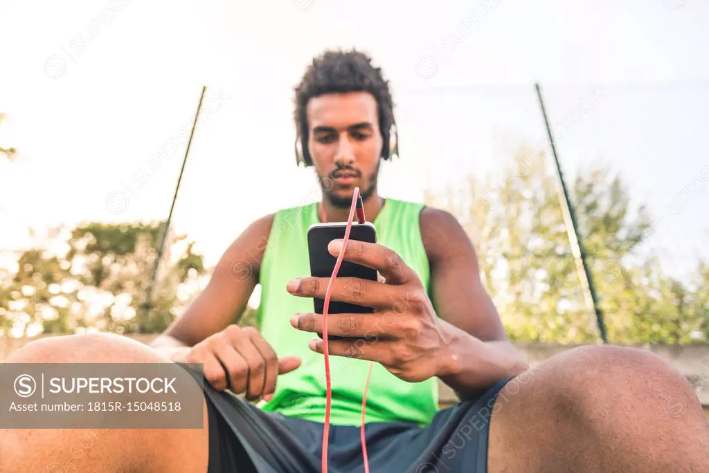 Basketball player listening music, smartphone and headphones