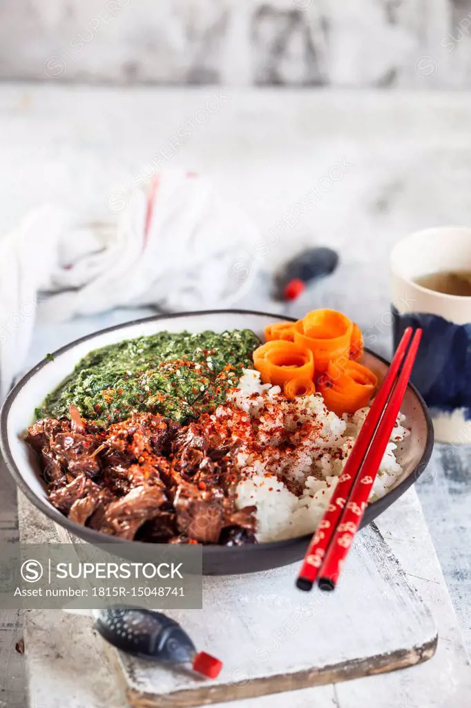 Vegan teriyaki bowl with pulled teriyaki beef made from jackfruit, spinach, rice and carrots